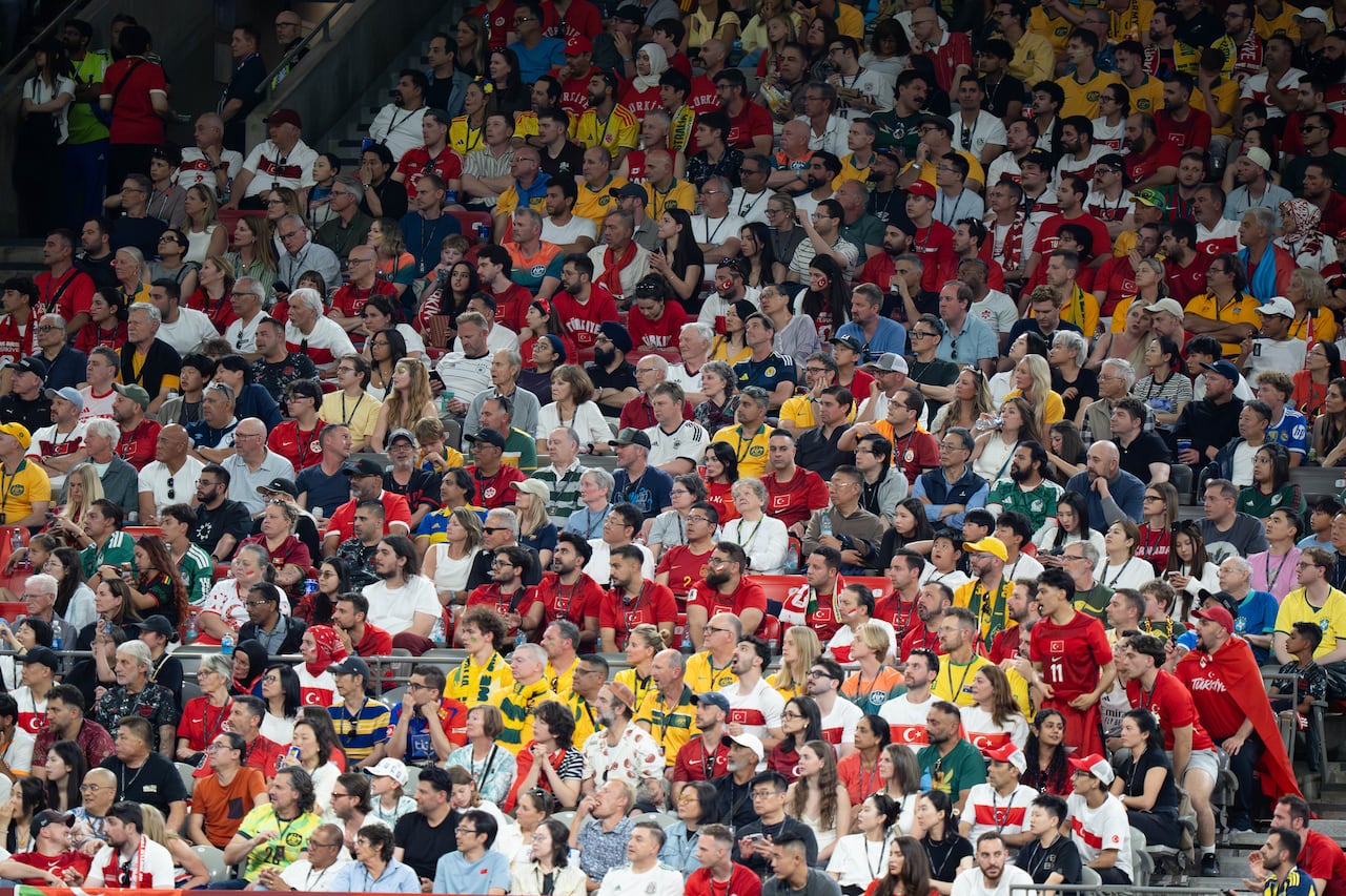 fans sit in stands at a stadium