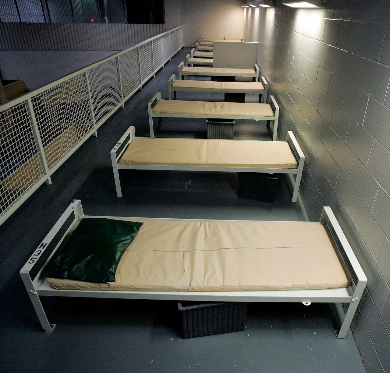 FILE - This Dec. 10, 2008, file photo shows a row of beds at the Elizabeth Detention Facility, a Corrections Corporation of America immigration facility in Elizabeth, N.J. CCA, the largest contractor for U.S. Immigration and Customs Enforcement, reac