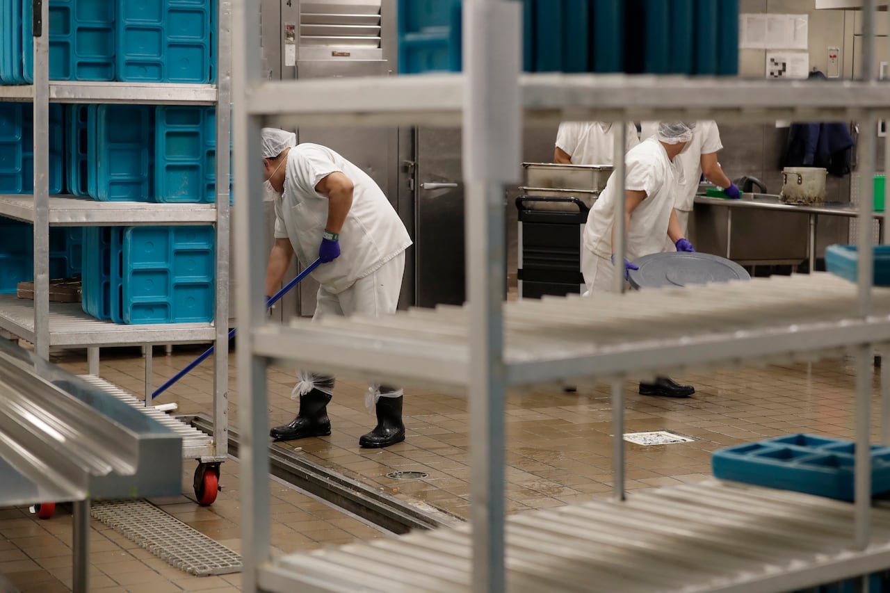 FILE - Workers are shown in the kitchen of The GEO Group's immigration detention center in Tacoma, Wash., during a media tour, Sept. 10, 2019. After a federal jury determined on Oct. 27, 2021, that detainee workers were entitled to minimum wage for c