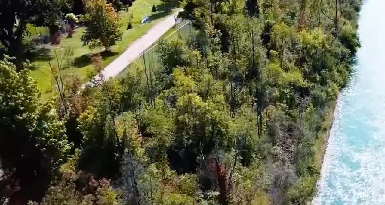 Trees and a canal are shown.