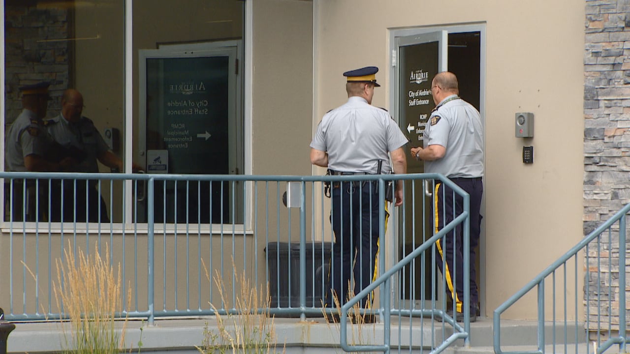 RCMP officers enter the detachment in Airdrie, Alta.