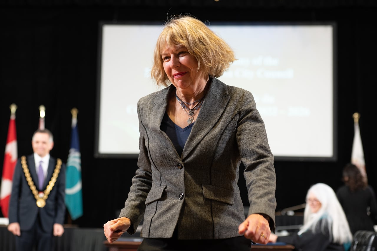 A politician walks away from a table, smiling.