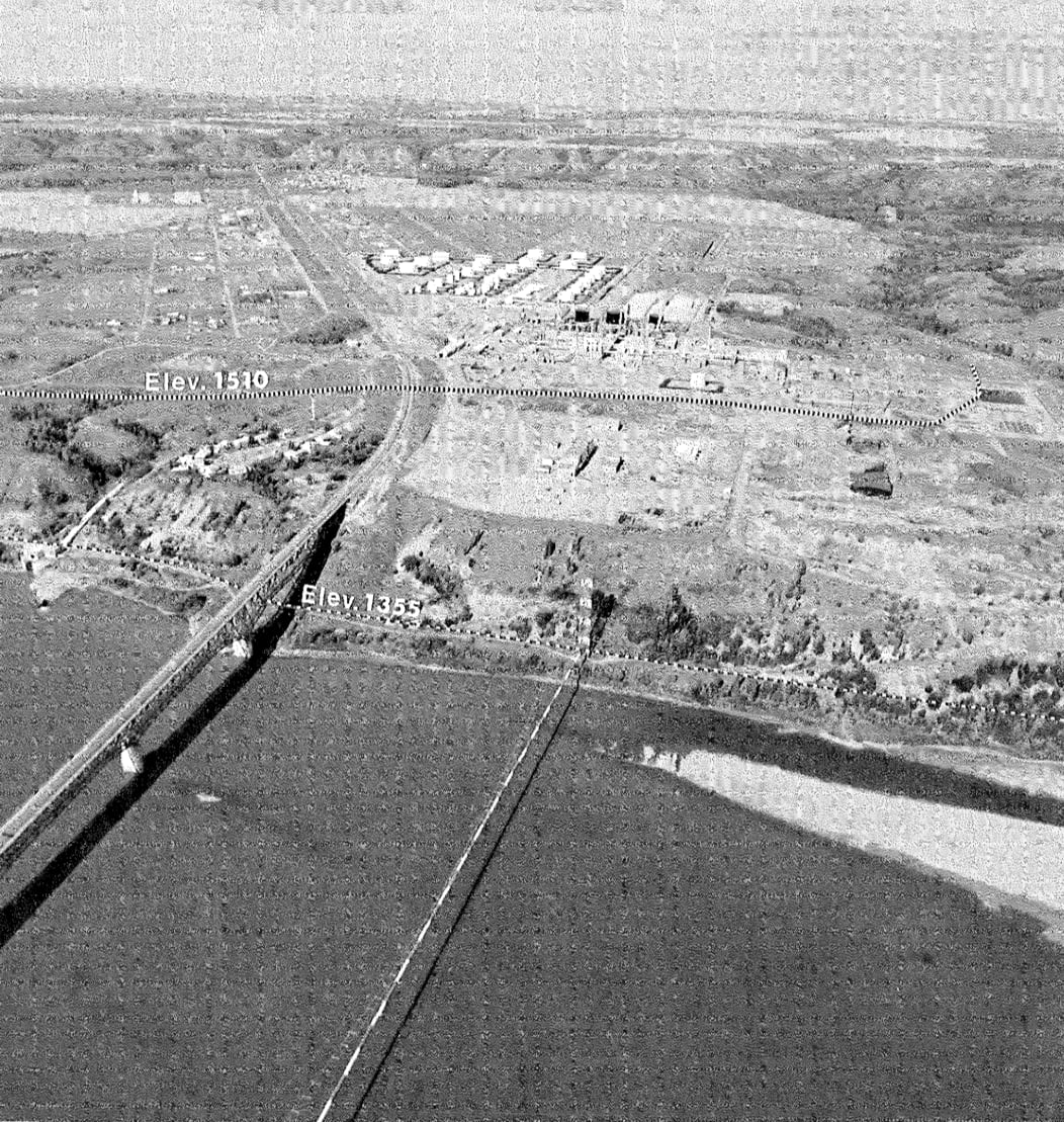 black and white aerial photograph of a river with a bridge crossing it, leading to an industrial area with elevations marked as 1355 and 1510 feet