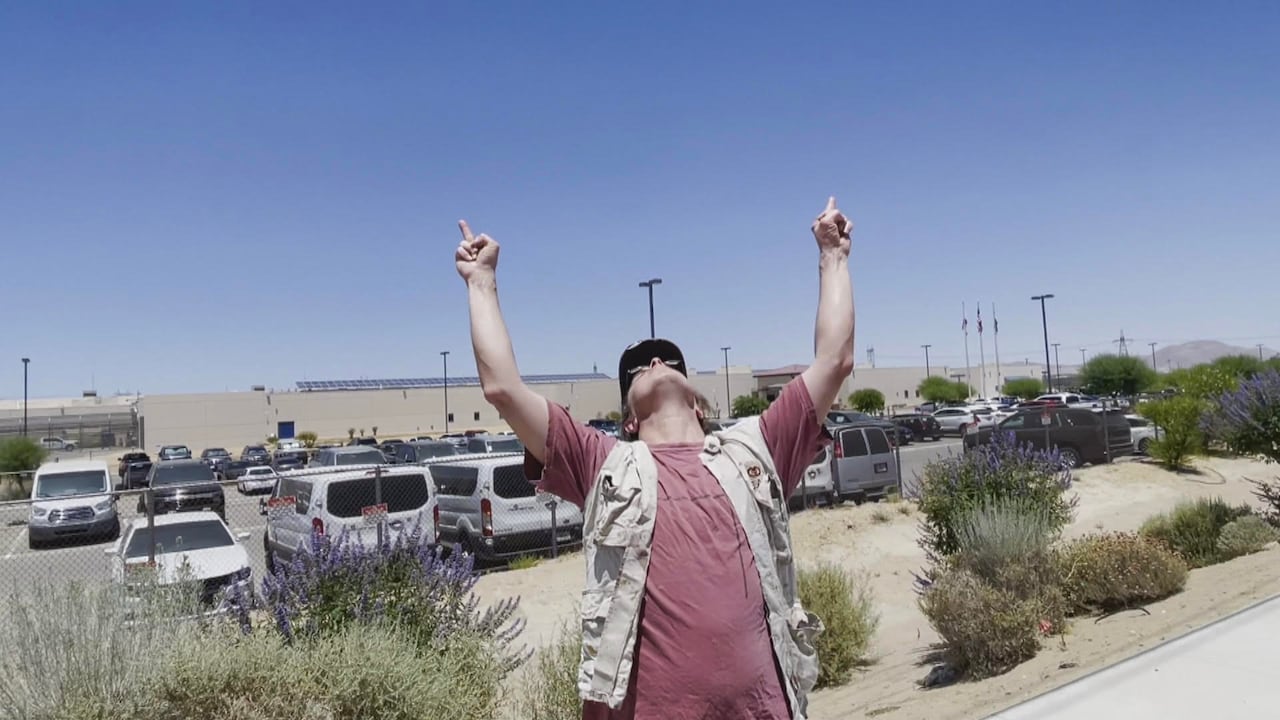 A man throws his head back and raises a finger on each hand.