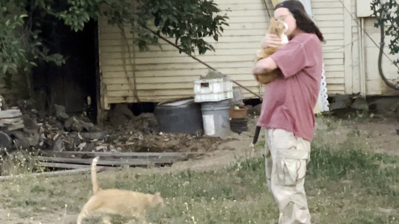 A man hugs a cat.