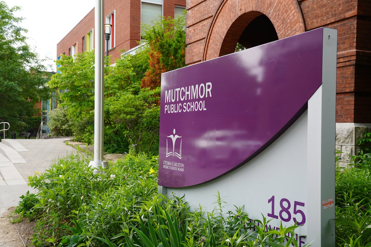 A shot of a building with a school sign in front of it.