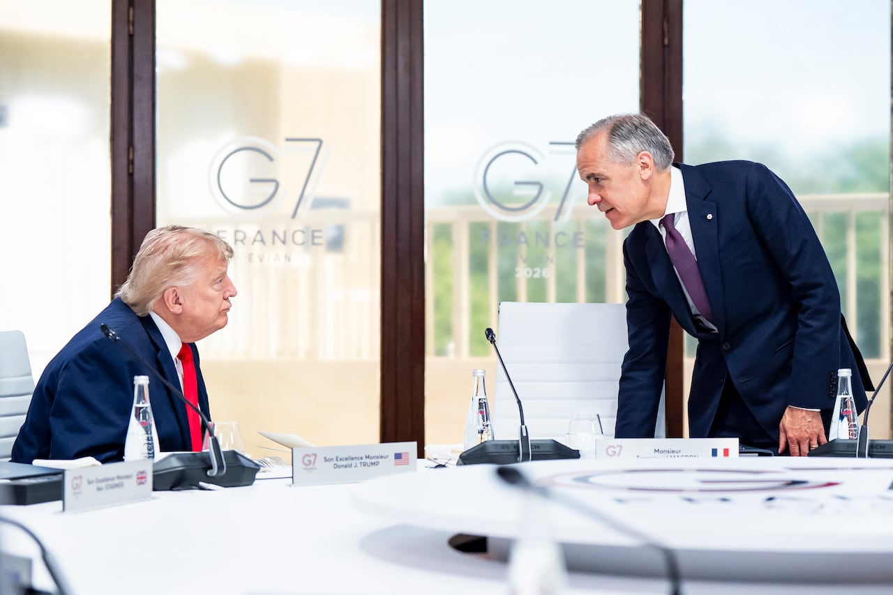 Two men speak in suits
