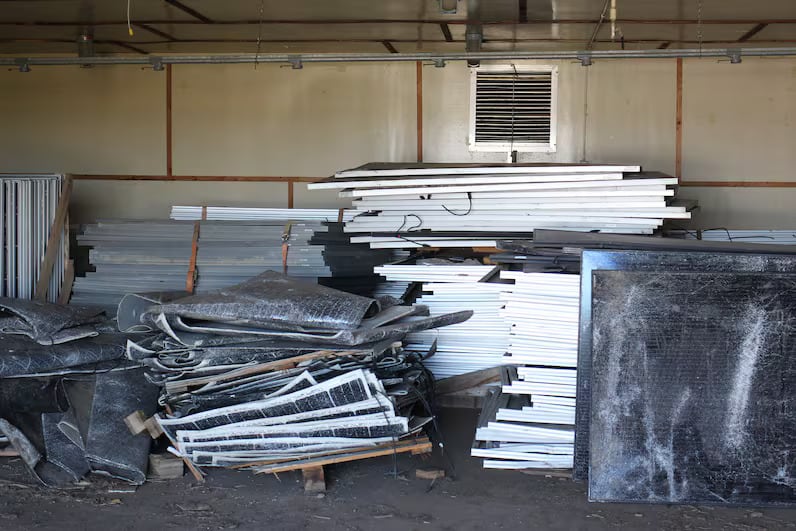 A pile of solar panel waste piled up in a storage space.