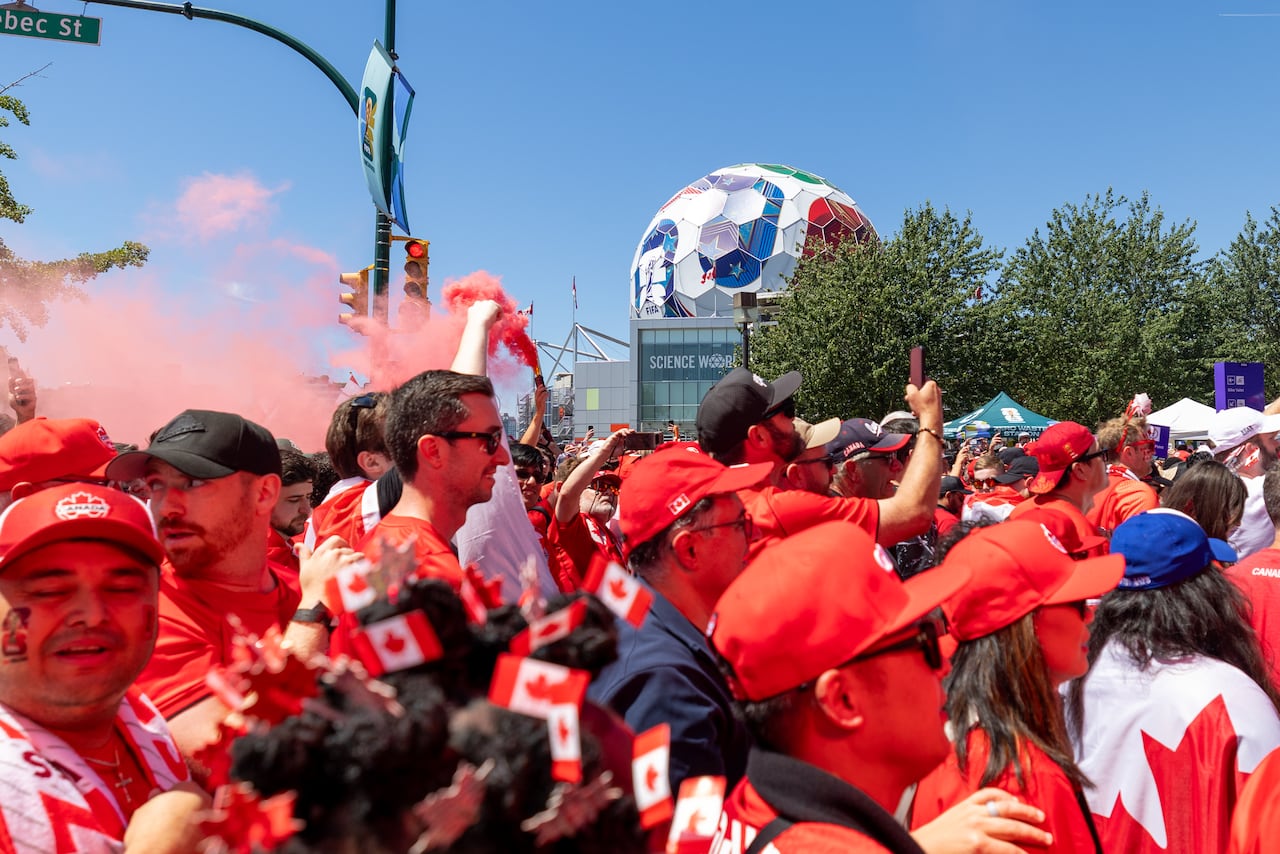 People in red walk by ScienceWorld in Vancouver