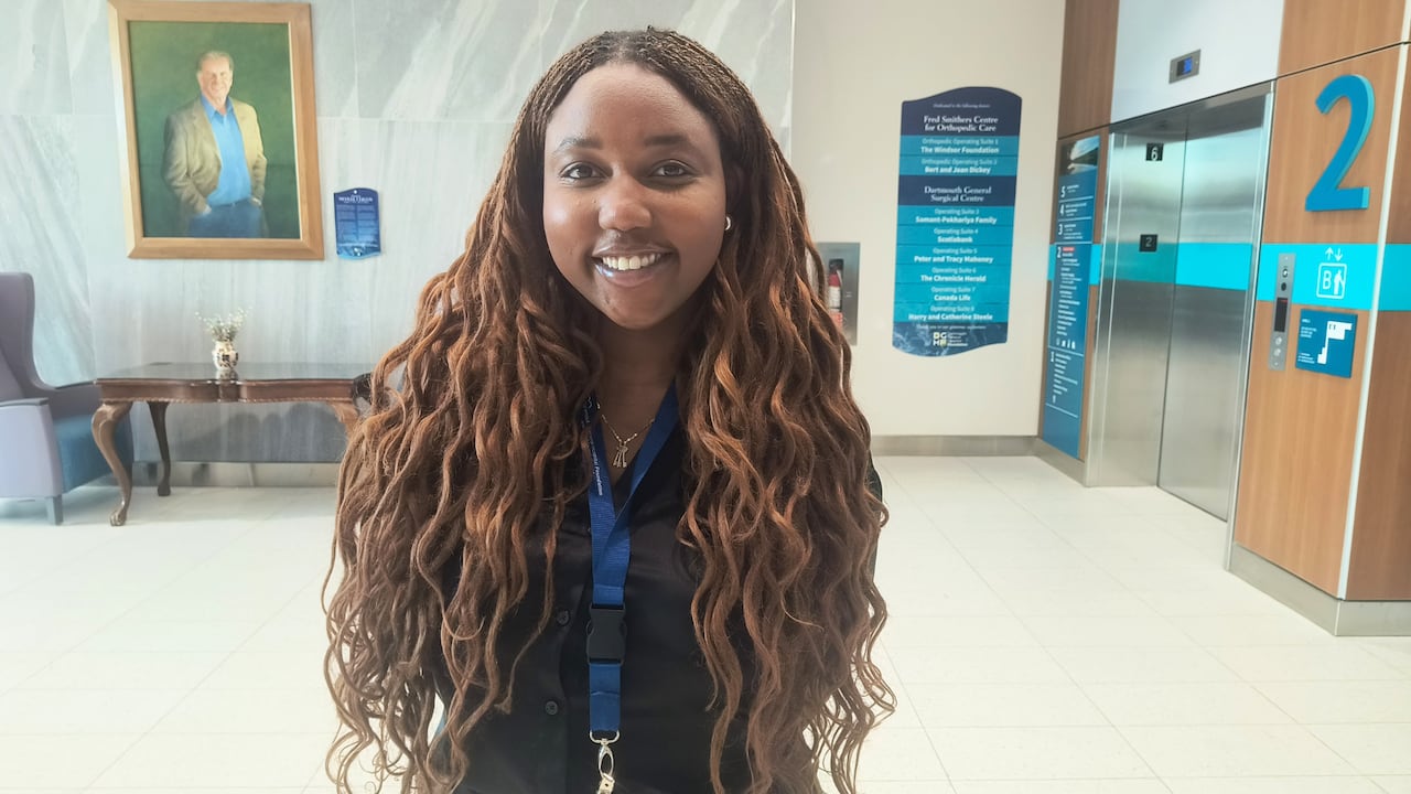 A woman stands in a hospital hallway.