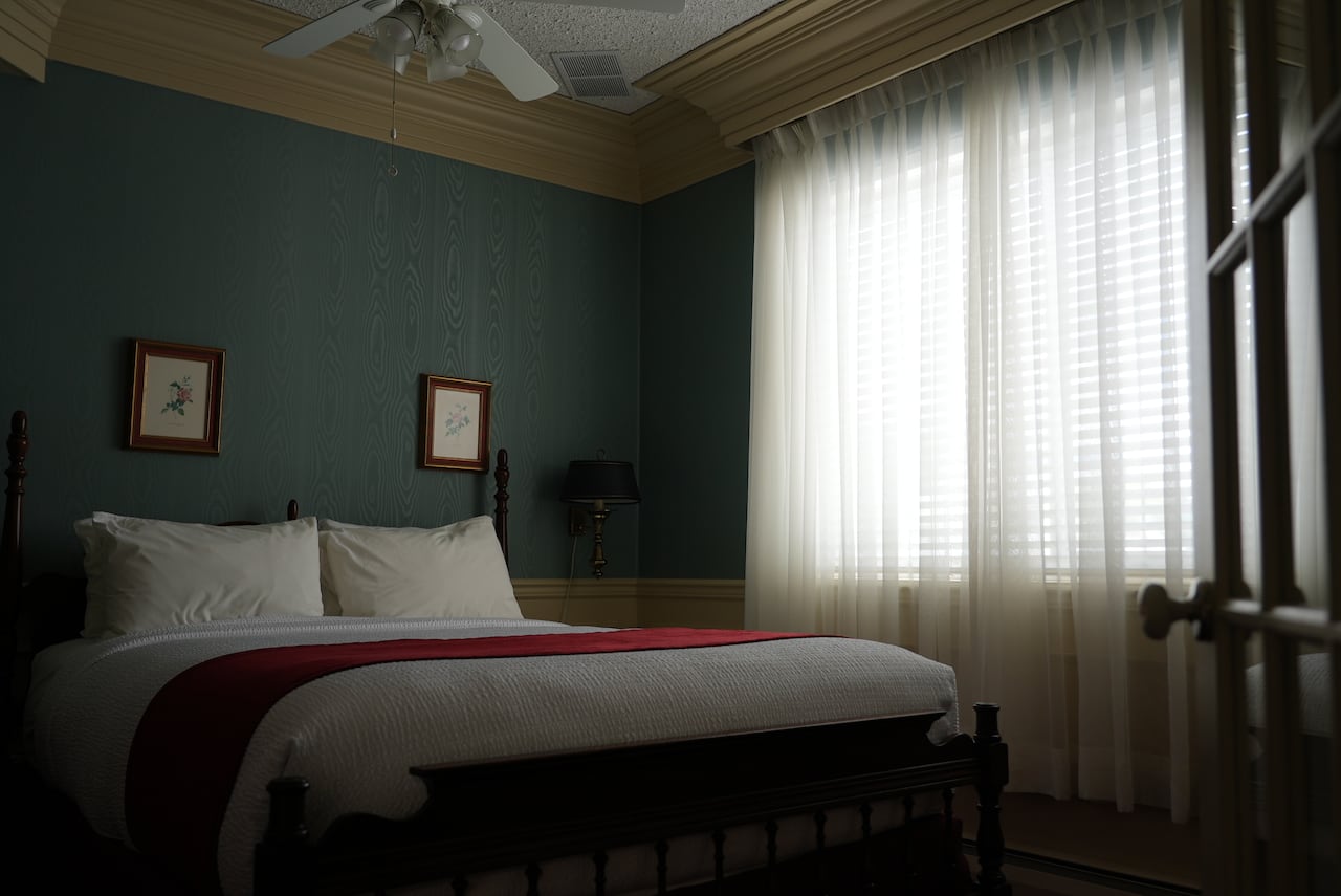 A hotel room with a bed and window.
