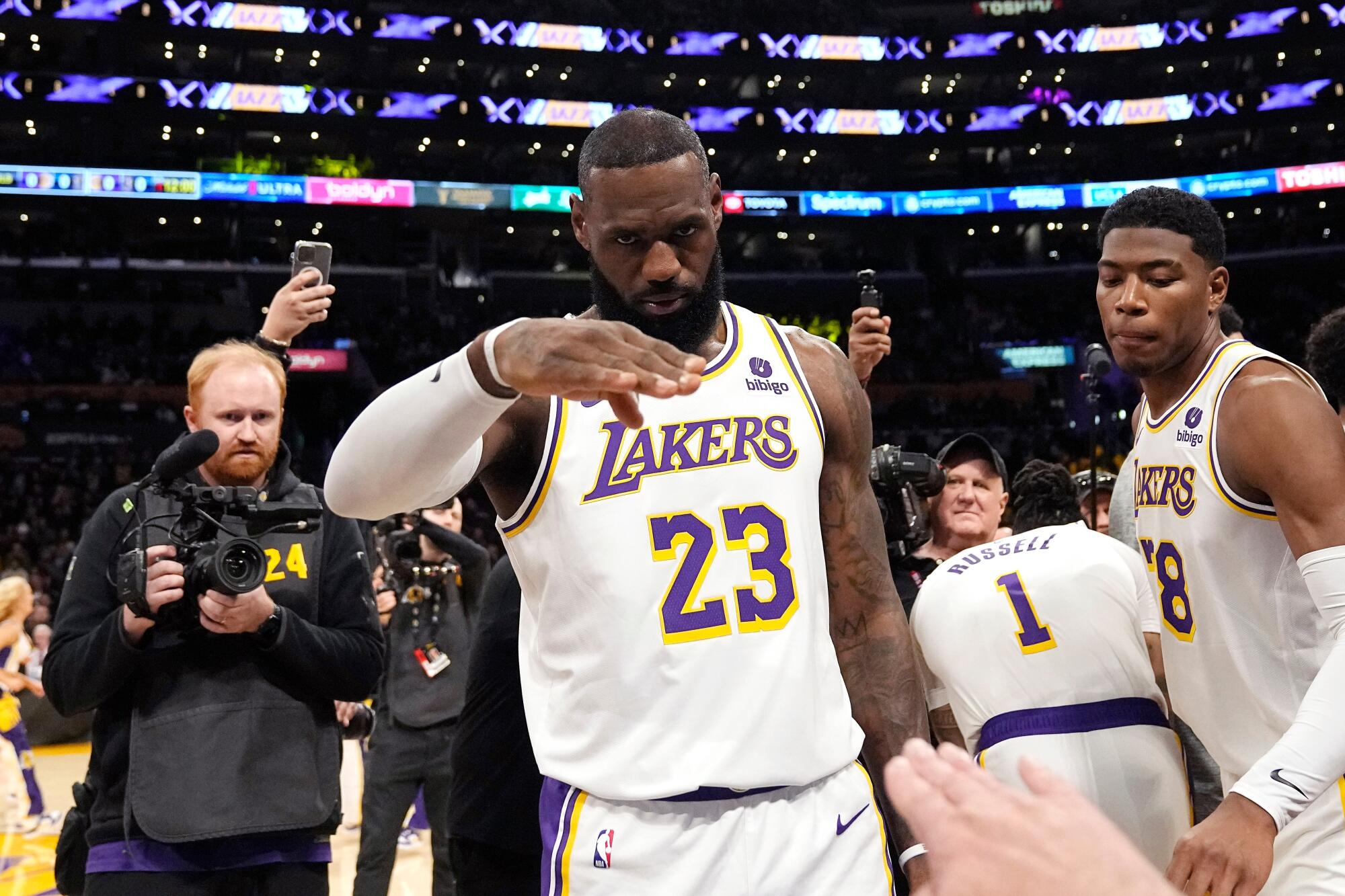 Lakers star LeBron James, center, salutes public address announcer Lawrence Tanter (not pictured) before a game in 2024.