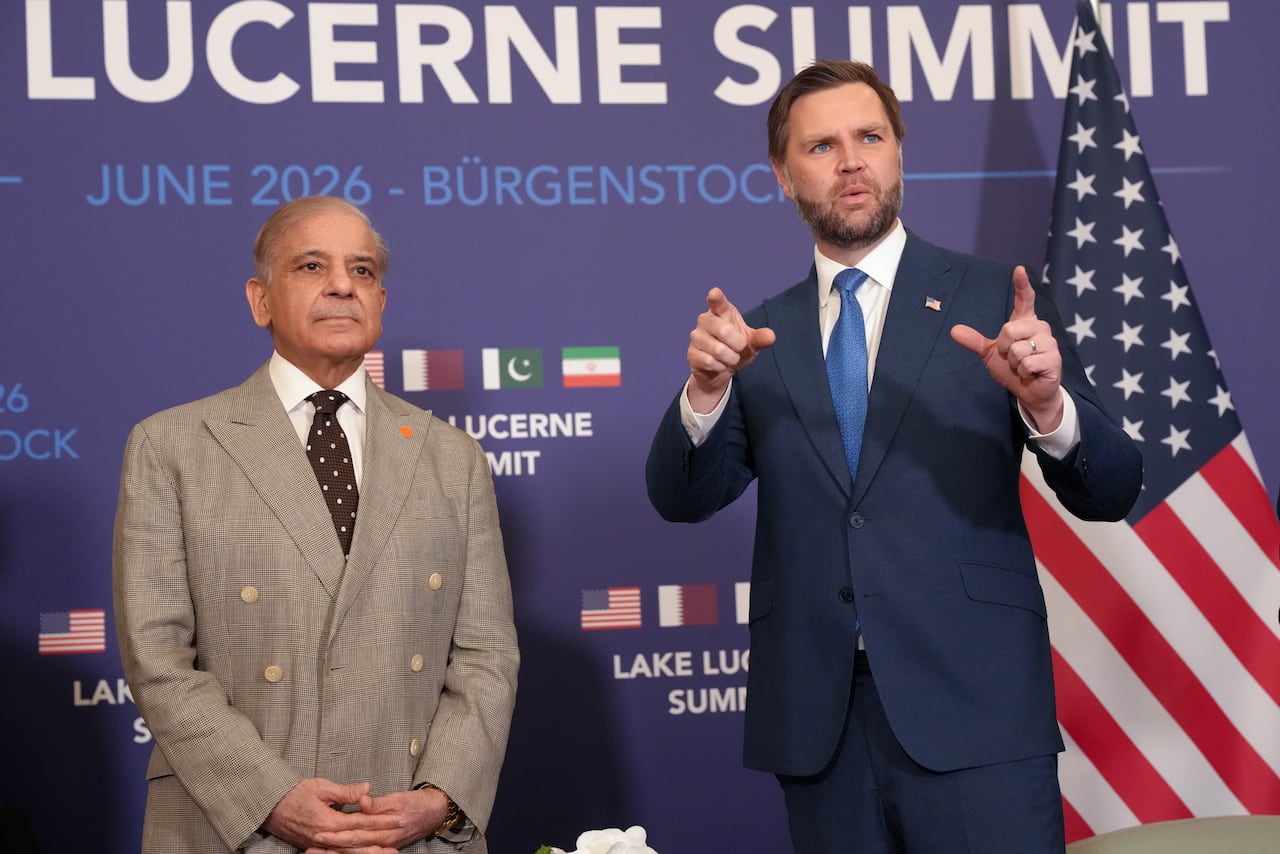 Two men in suits pose for a photo.