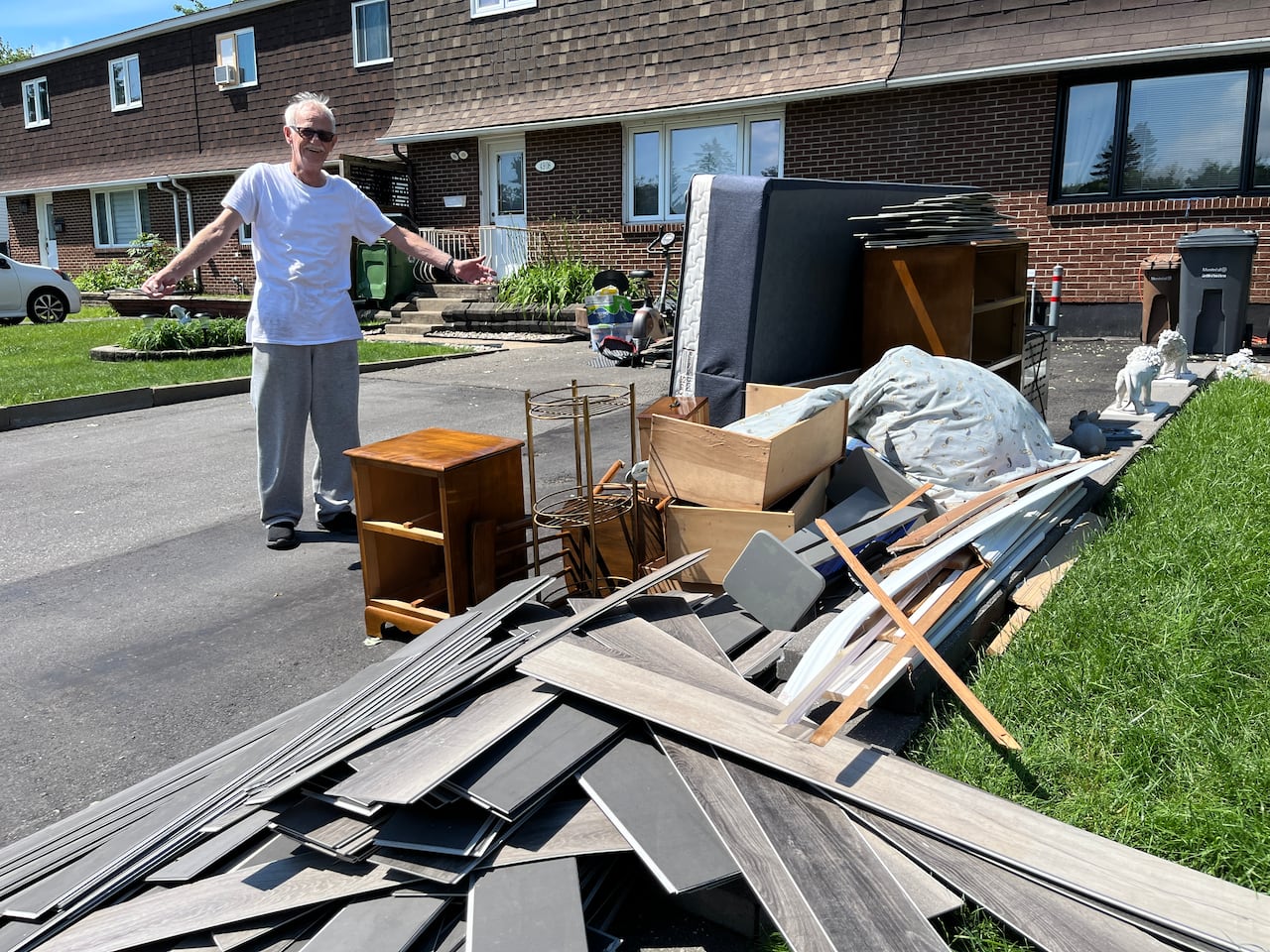 A man stands in front of damaged items from a flash flood Saturday.