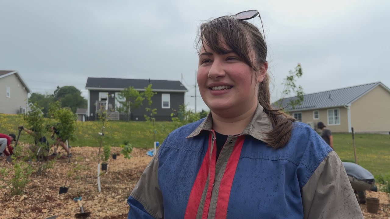 A person with a brown ponytail and blue jacket.