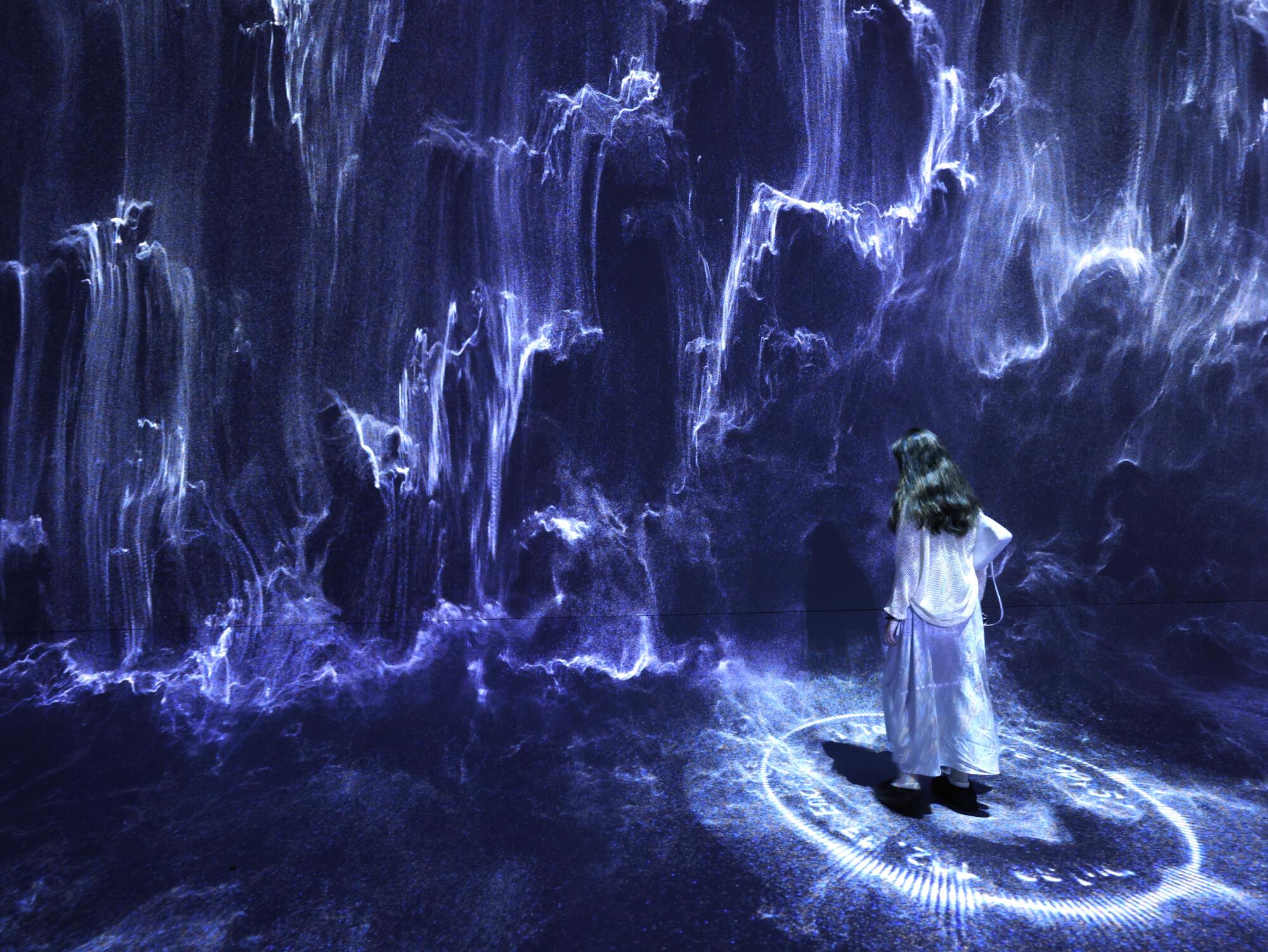 A visitor creates a ghostly character surrounded by imagery 