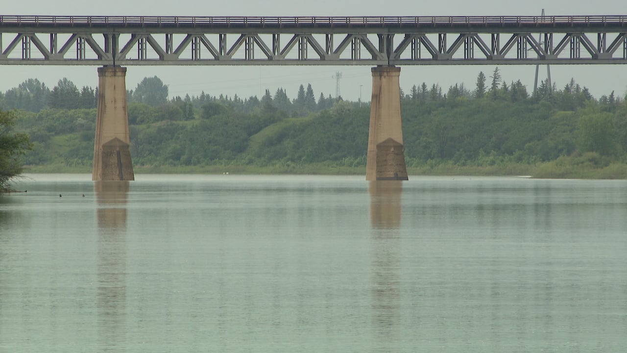 A bridge can be see in the background of a river view.