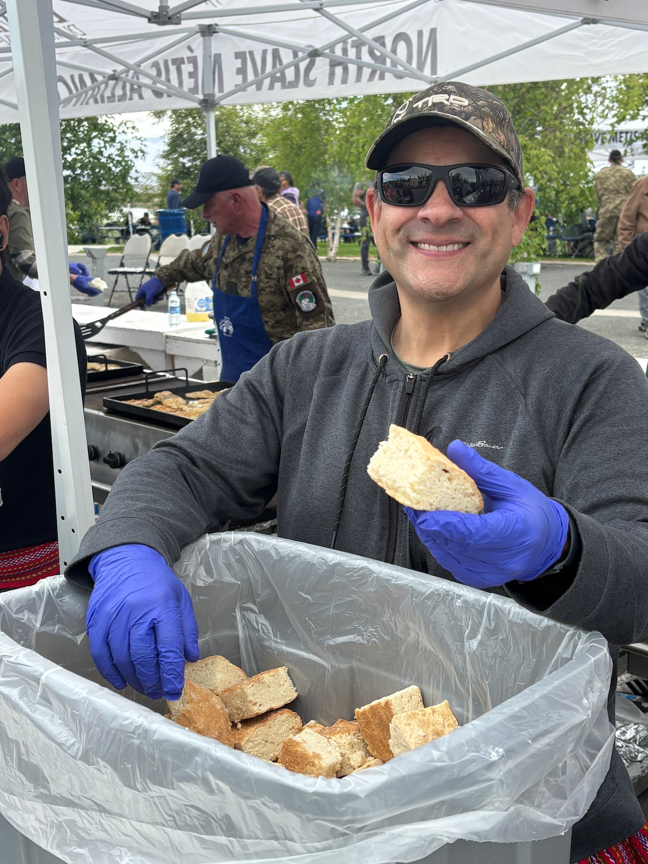 Warren Whitford serves up bannock at the North Slave Métis Alliance's annual Indigenous Peoples Day fish fry at Somba K'e Park in Yellowknife.