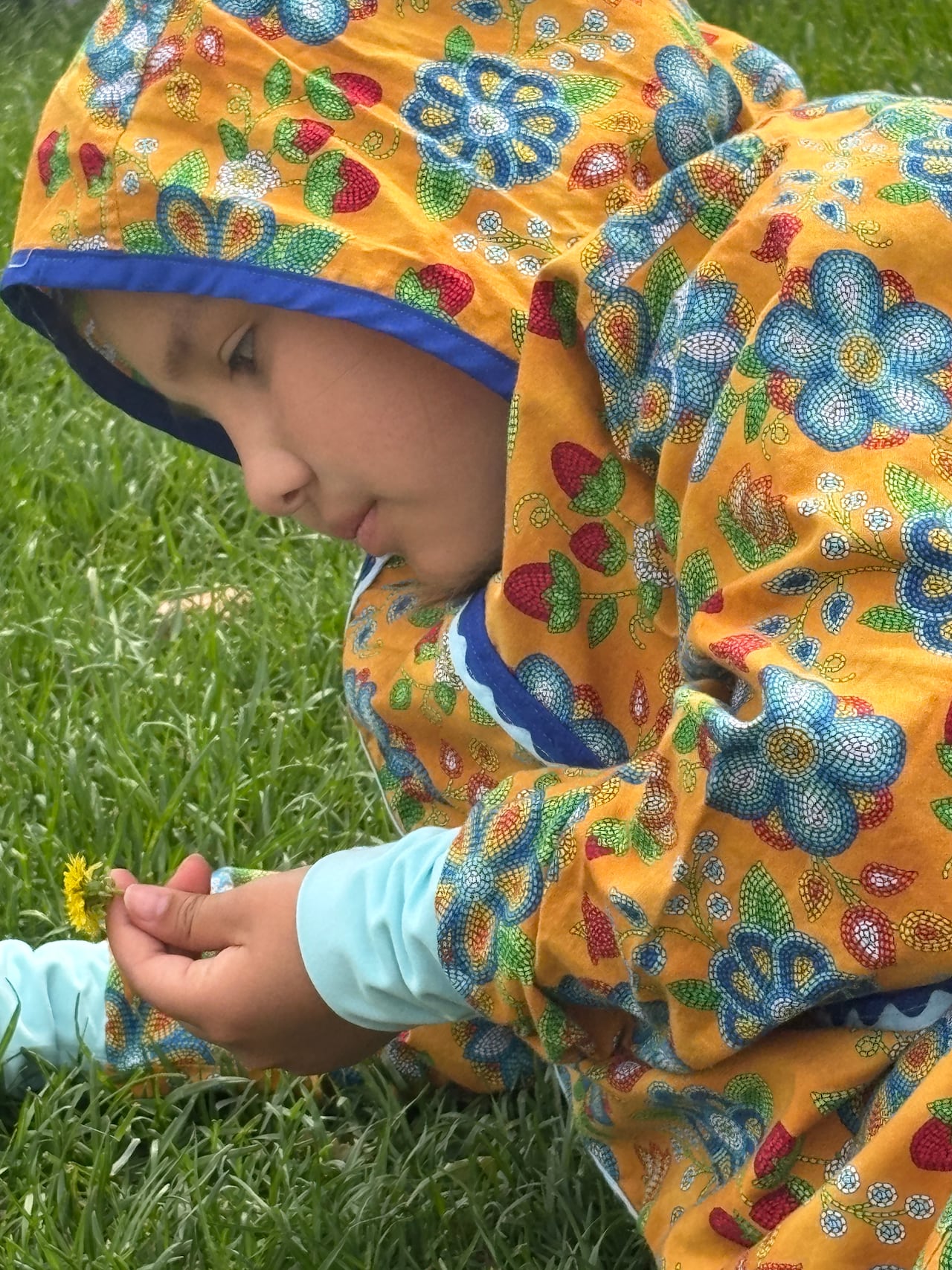 Lylah Desjarlais took time out to literally sniff the flowers during the Indigenous Peoples Day celebrations.