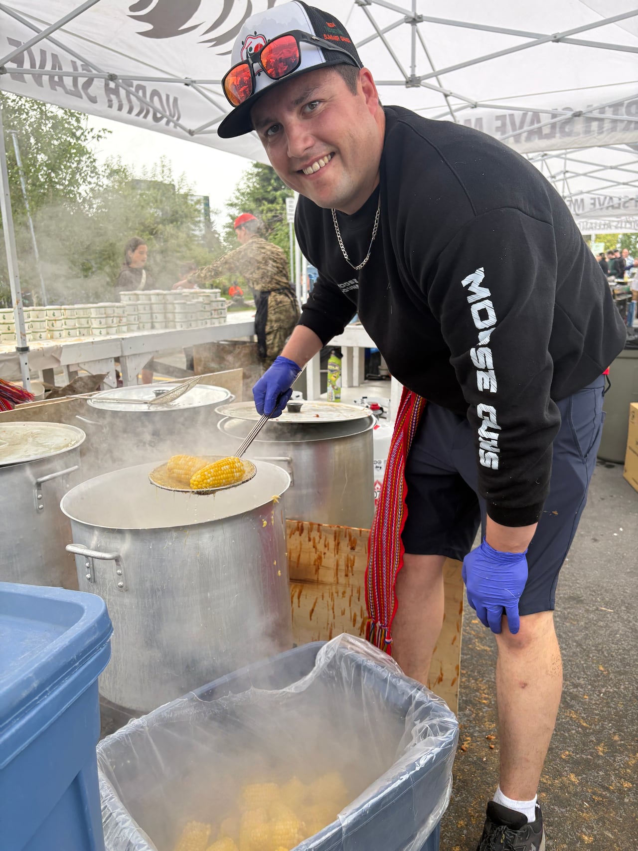Alan Harman Jr., vice president of the North Slave Métis Alliance, fishes corn on the cob out of one of several vats being used to prepare side dishes at the annual Indigenous Peoples Day fish fry.