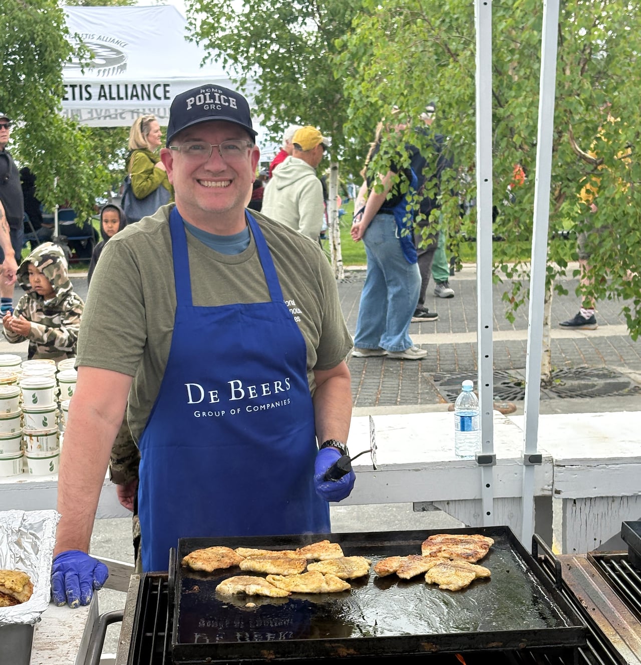 Tyson Smith, an RCMP volunteer, fries fish for a line of visitors that extended the entire length of Somba K'e Park in Yellowknife.
