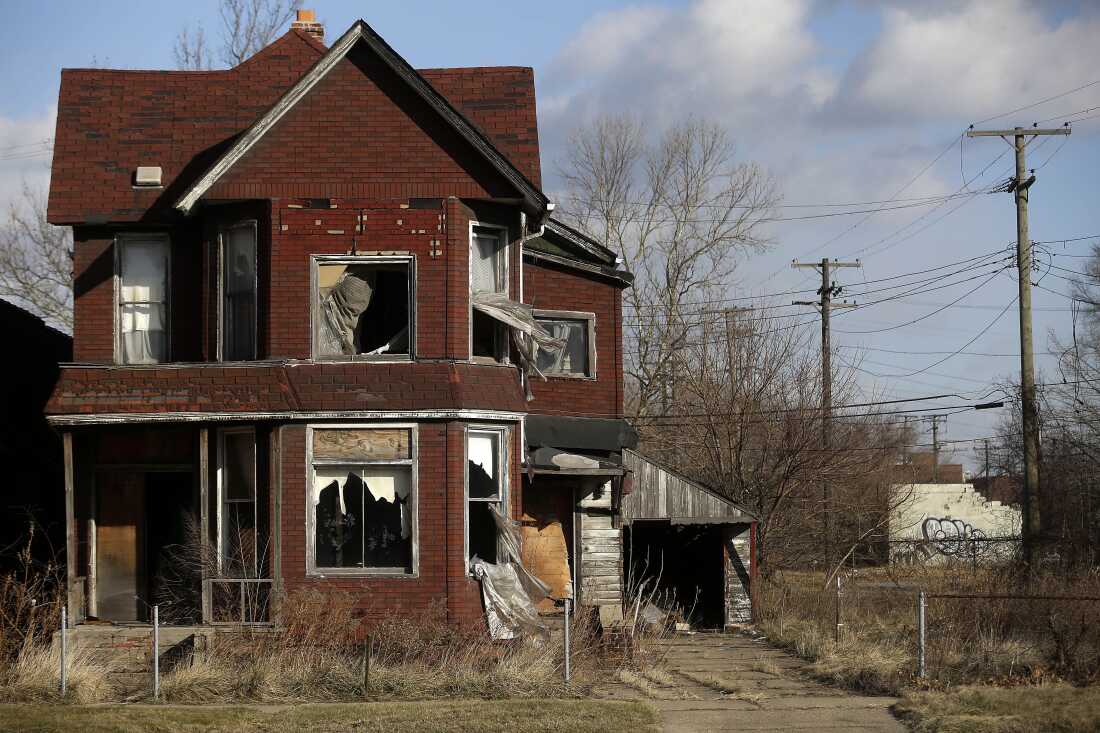 TO GO WITH AFP STORY by Joe Szczesny, US-city-Detroit-auto-debt Curtains flap outside the broken window of an abandoned home December 31, 2014 in Detroit, Michigan. After the largest municipal bankruptcy in US history, Detroit hopes outsiders will see the city's potential not the history of racial conflict, financial crises and citizen flight that has cut its population in half since 1960. AFP PHOTO/JOSHUA LOTT (Photo credit should read Joshua LOTT/AFP via Getty Images)
