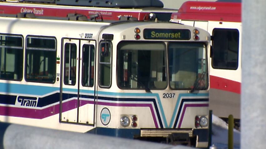 A blue transit vehicle with light blue, dark blue and purple stripes down the side.