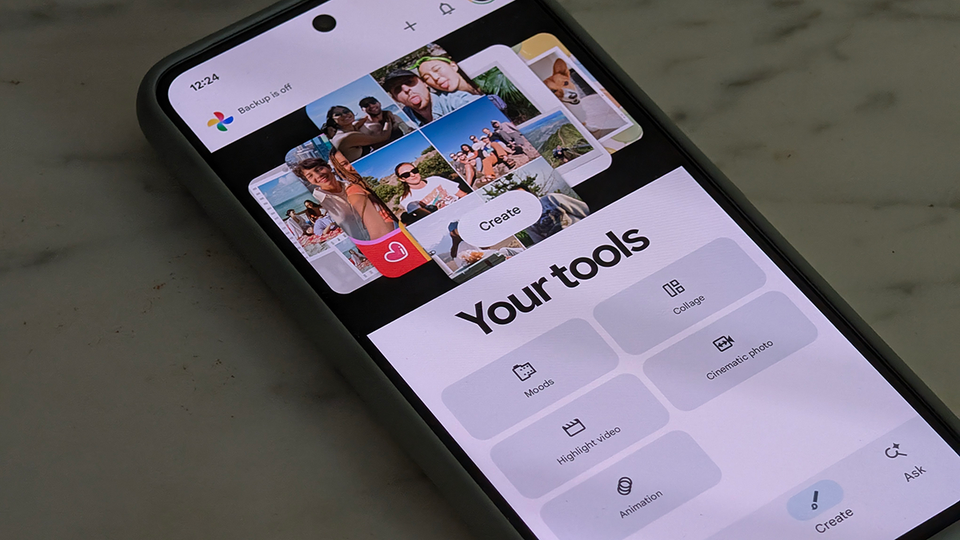 A close-up photograph of a Google Pixel smartphone resting on a marble surface, displaying the Google Photos app icon on the home screen.