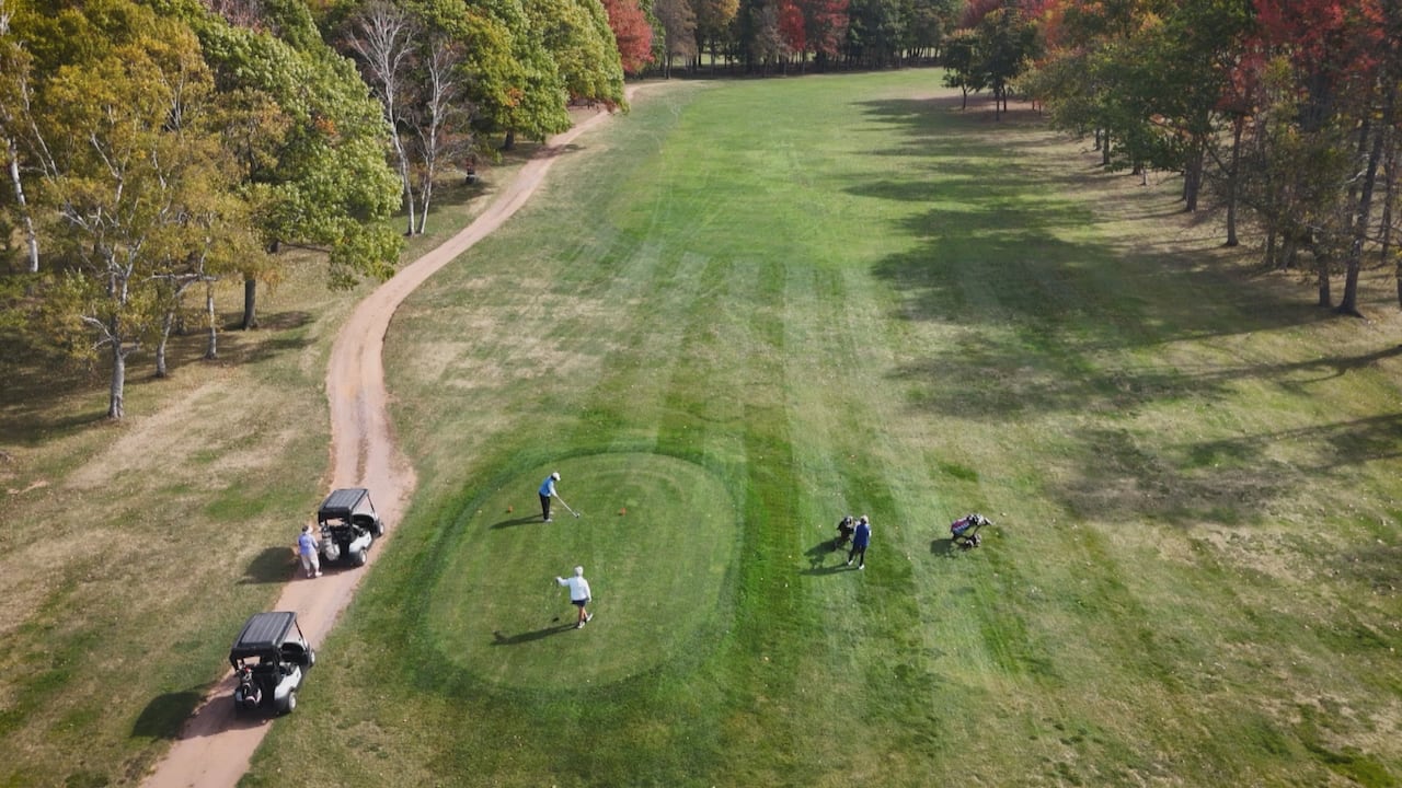 A drone shot of people on the tee of a golf course
