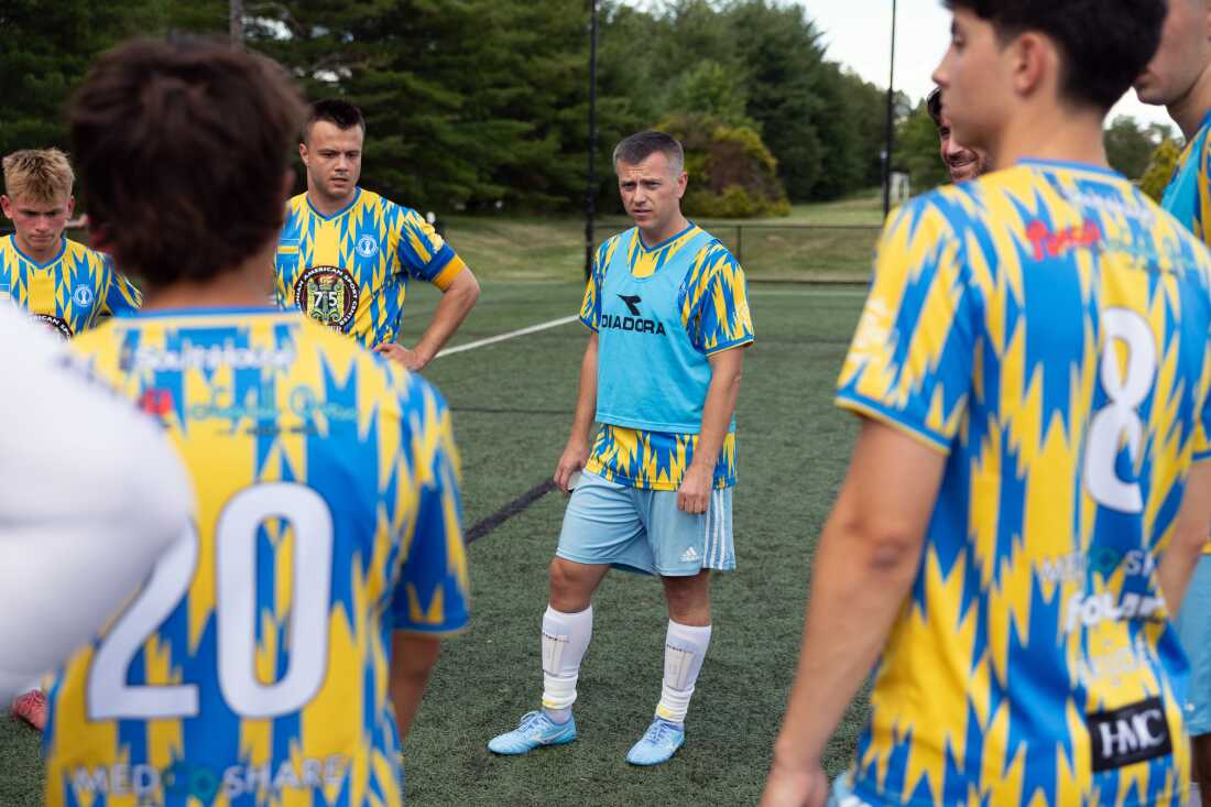 Roman Chuprynyak stands on a soccer field among members of the Philadelphia Ukrainian Nationals soccer team, giving them a pep talk at Tryzub Ukrainian American Sport Center on June 21, 2026.