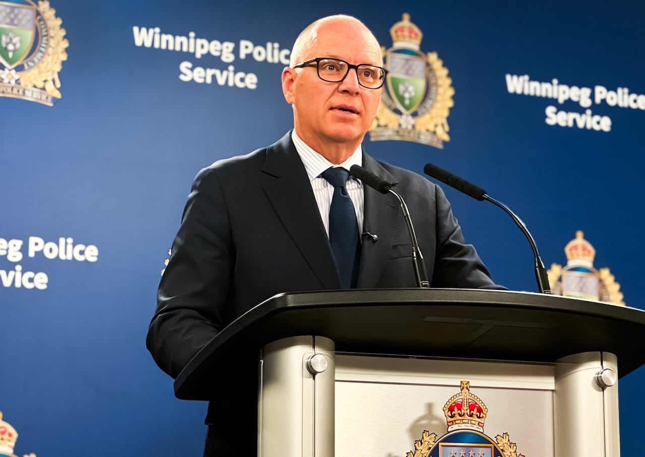 A man in glasses stands at a podium.