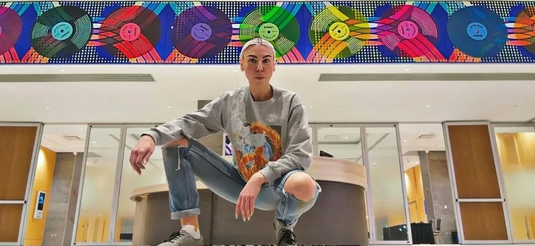 woman stands in front of mural