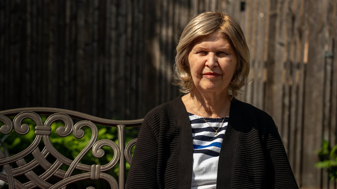 a woman sitting on a bench outside. 