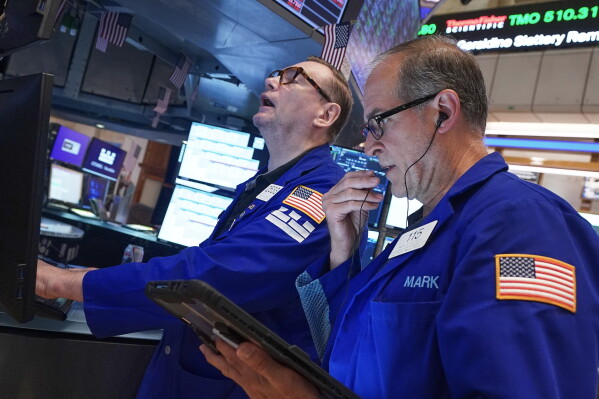 Specialist Patrick King, left, and trader Mark Puetzer work on the floor of the New York Stock Exchange, Friday, June 26, 2026. (AP Photo/Richard Drew)