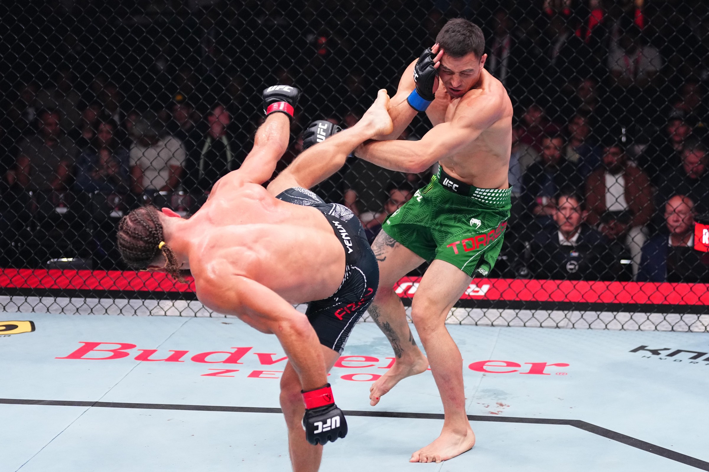 BAKU, AZERBAIJAN - JUNE 27: (L-R) Rafael Fiziev of Kazakstan drops Manuel Torres of Mexico with a kick in a lightweight fight during the UFC Fight Night event at National Gymnastics Arena on June 27, 2026 in Baku, Azerbaijan. (Photo by Jeff Bottari/Zuffa LLC)