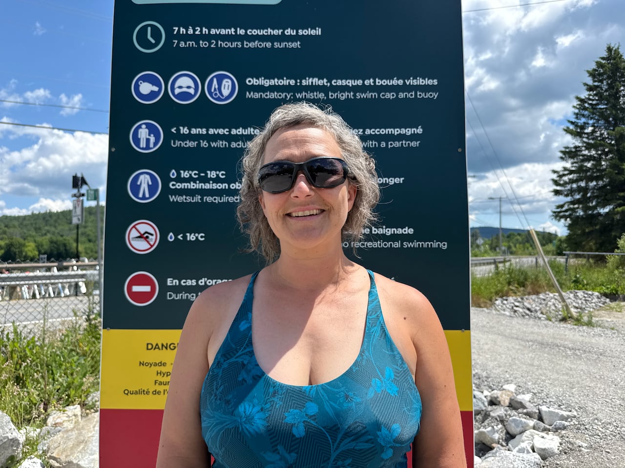 An image of a woman in front of a sign with a list of rules.