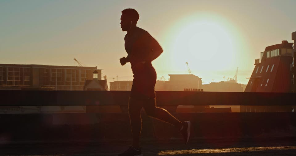 A young executive running at sunrise before starting his workday and business meetings.