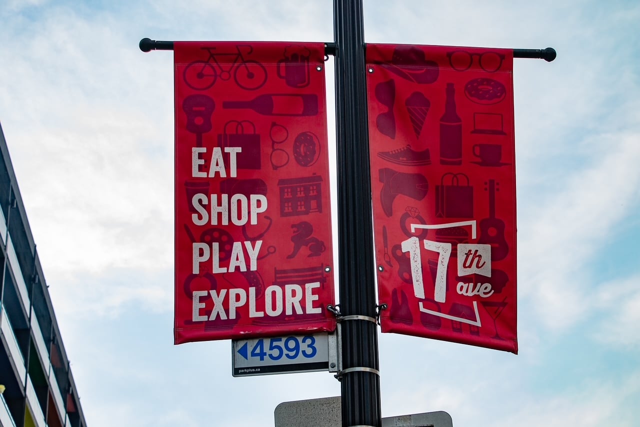Close up of a sign promoting 17th Avenue to eat, play, shop and explore