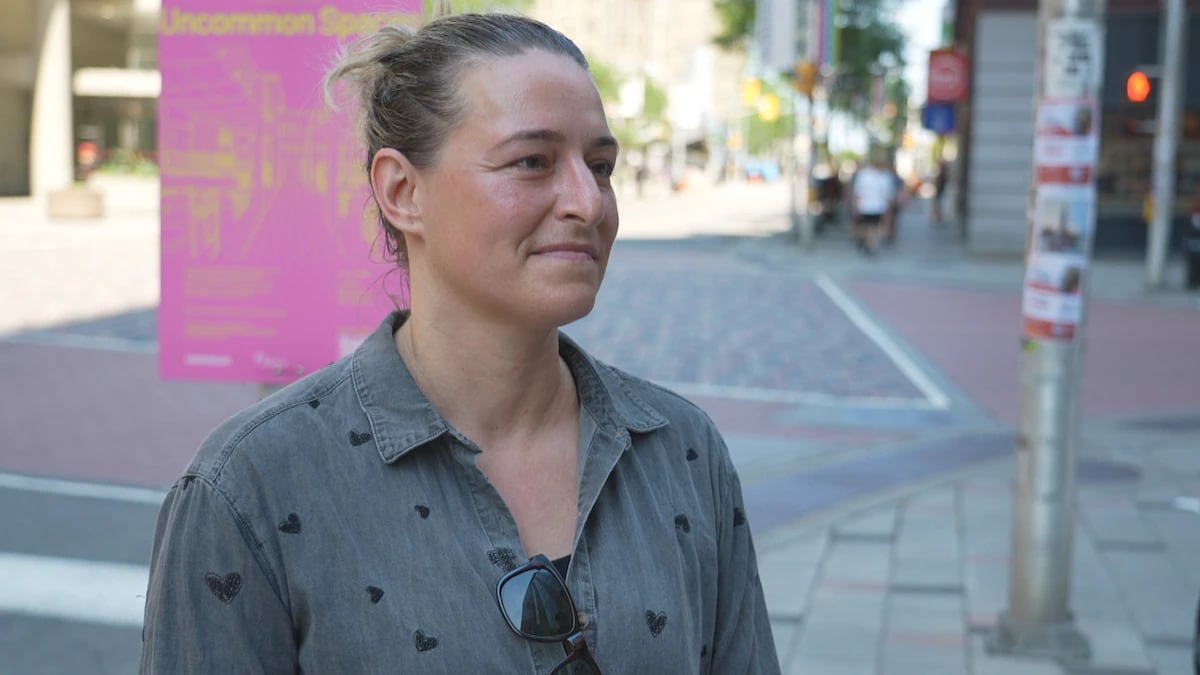 a woman wearing a grey button up shirt