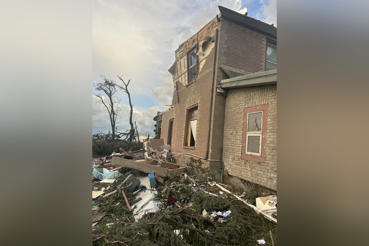 A brick home is broken and damaged from a tornado