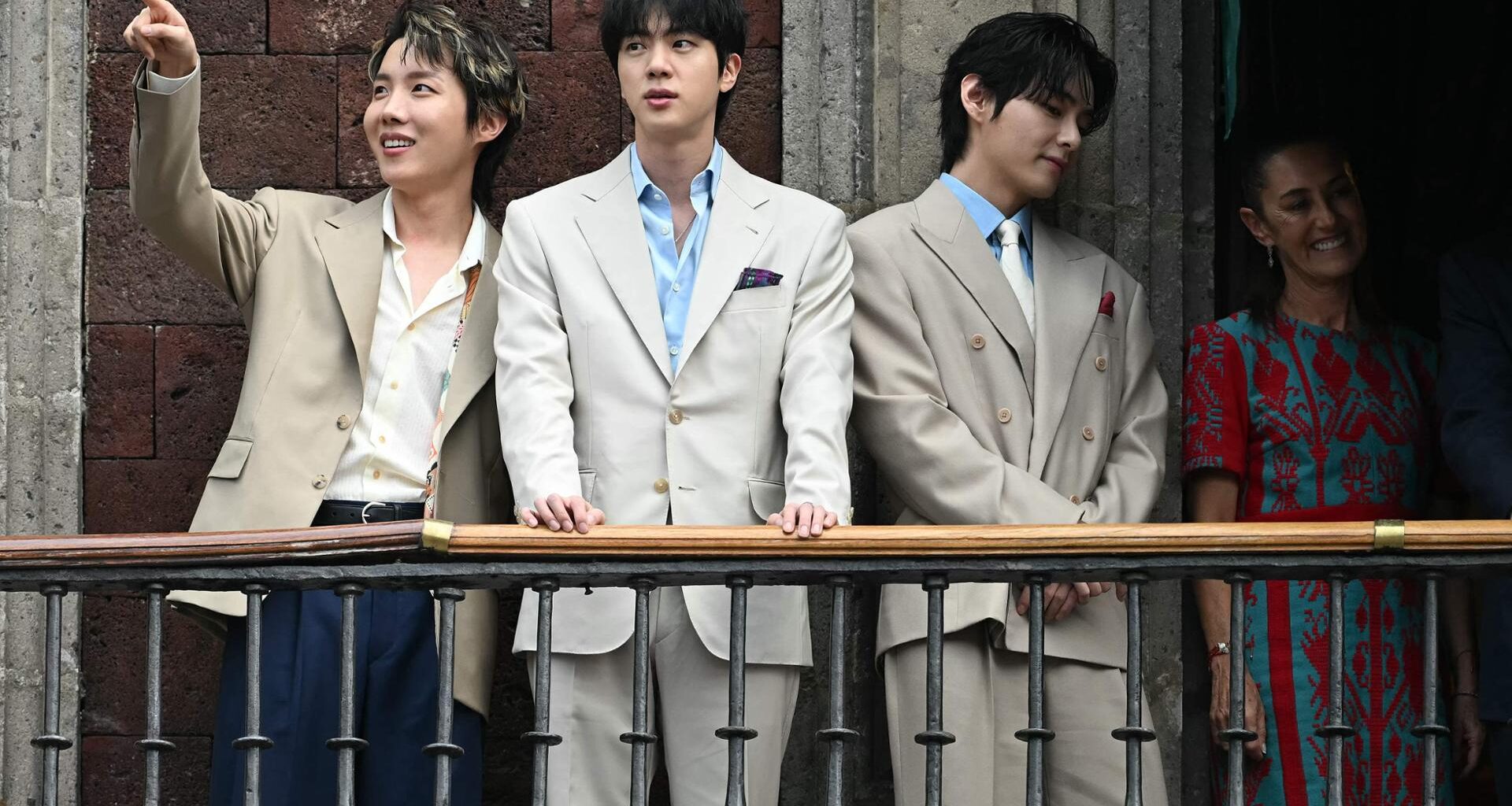 From left, J-Hope, Jin and V from K-pop boy band BTS acknowledge fans past Mexico President Claudia Sheinbaum from the balcony of the National Palace at Zocalo square in Mexico City, May 6. AFP-Yonhap