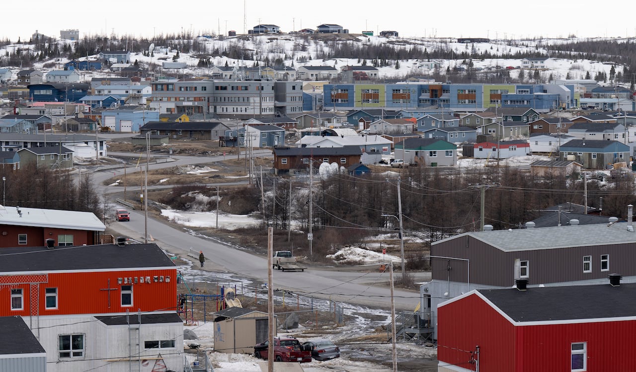 Buildings, cars and trucks are seen in a snowy town.