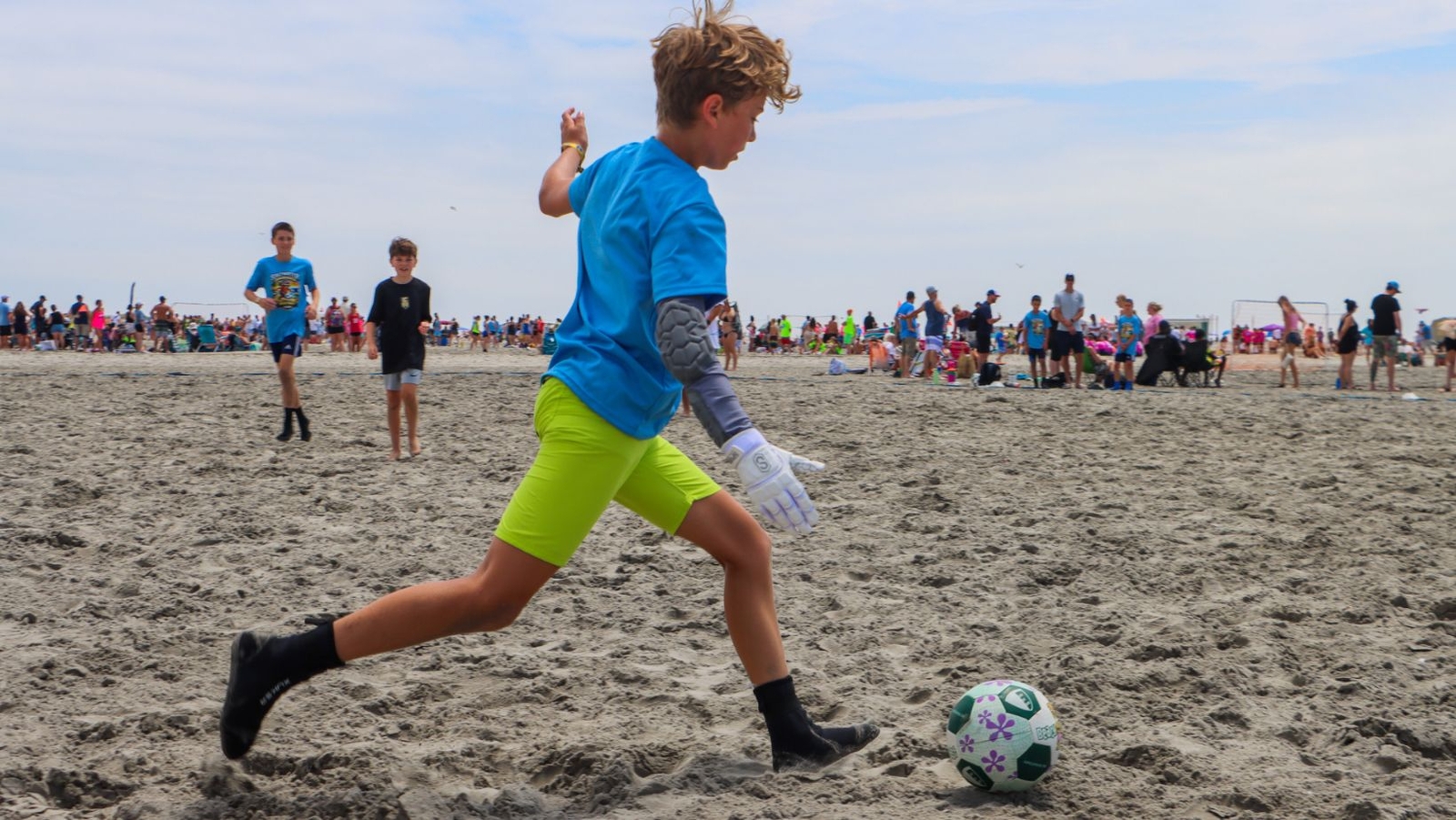 Kids play soccer in the sand during Cape Express Beach Blast