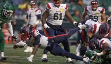 Football running back dives forward with the ball.