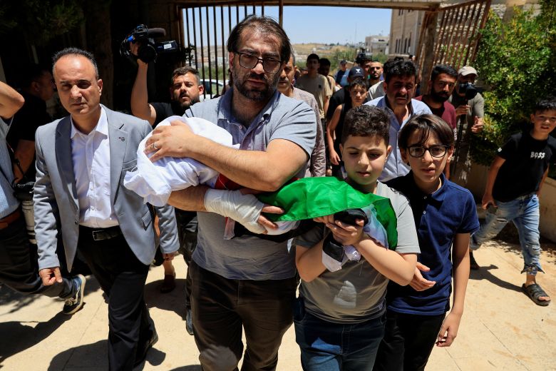 Father and brother of Sam Abu Haykal, a 7-month-old Palestinian child who was killed by Israeli soldiers, carry his body during his funeral in Hebron in the Israeli-occupied West Bank, June 6, 2026.