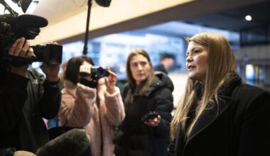Amber Bracken speaks in front of journalists with cameras and microphones