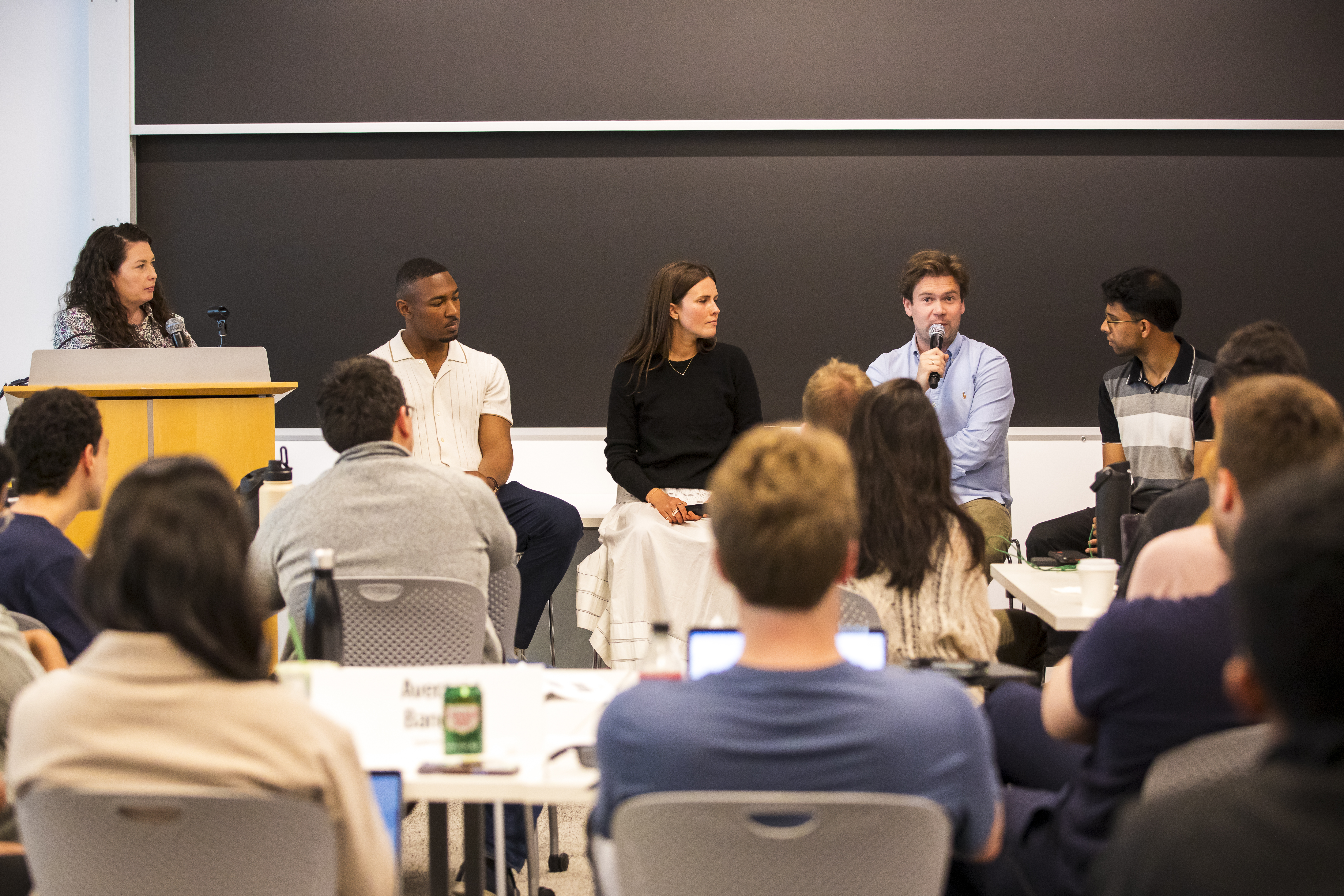 Four alumni on a panel in front of a classroom.