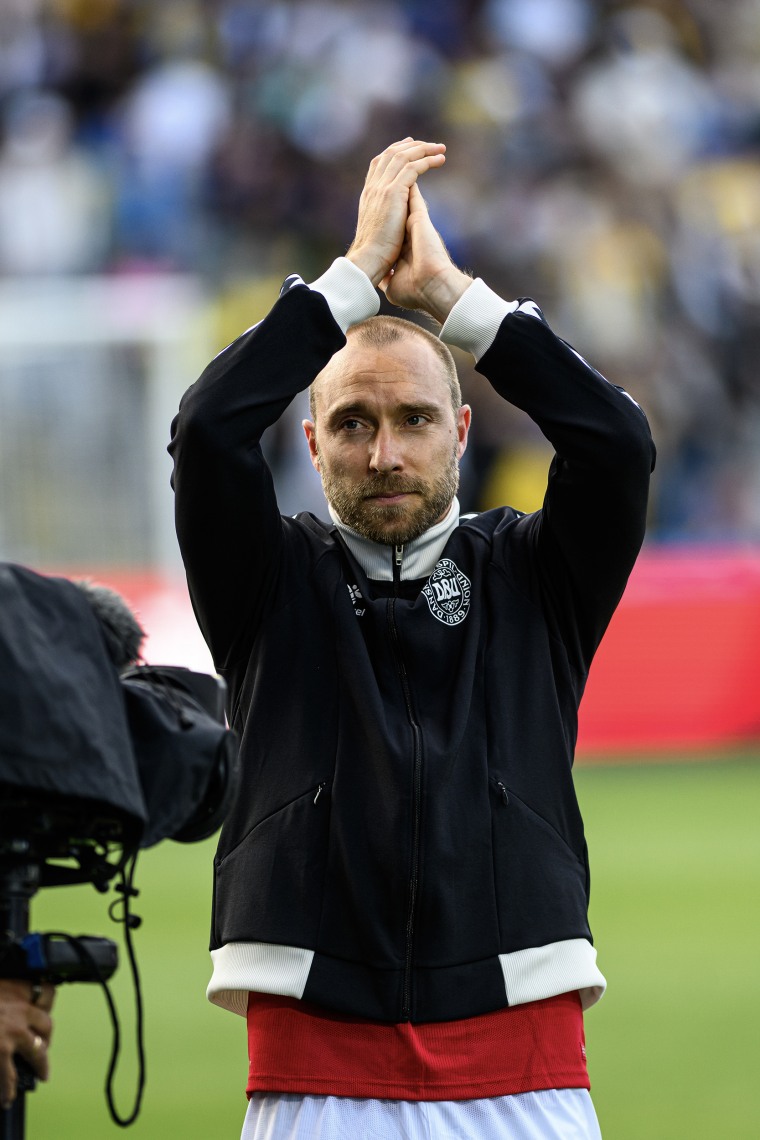 Christian Eriksen clasps his hands over his head.
