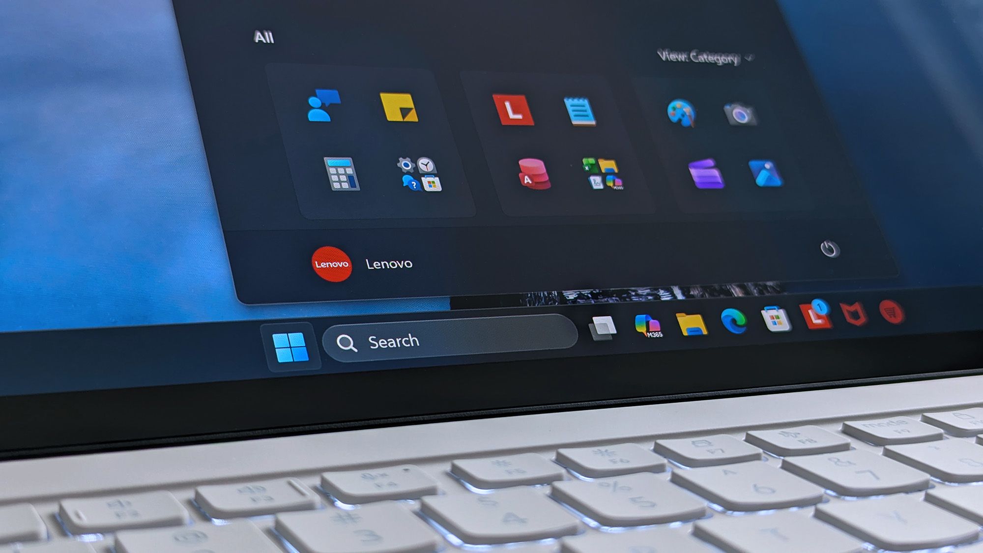 A Lenovo Yoga Slim 7i Ultra (Gen 11) Aura Edition laptop screen shows a home screen with open taskbar featuring app icons.