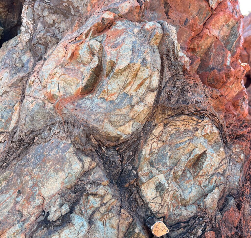 Close image of grey and red stone surface. Rock at the meteorite impact point